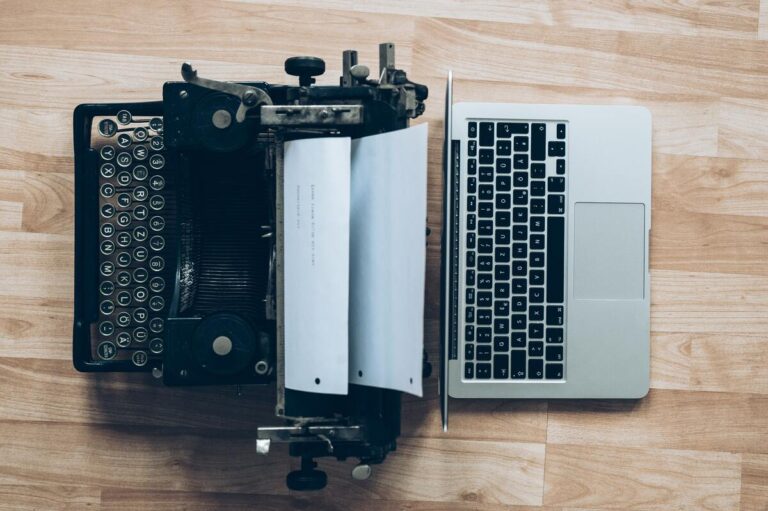 Symbolbild Zurück in die Zukunft: Schreibmaschine und ein gegenüber liegender Laptop