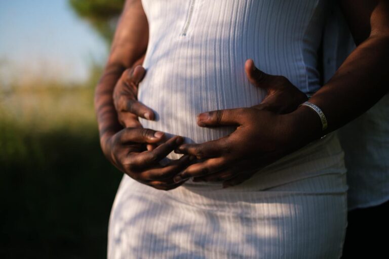 Symbolbild Tattooentfernung in der Schwangerschaft: Eine schwangere Frau und ihr Partner, die beide den Bauch halten