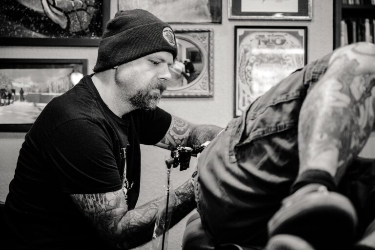 Symbol Bild: Cover-up Tattoo Motive: Tattoo-Artist sticht Tattoo am Rücken