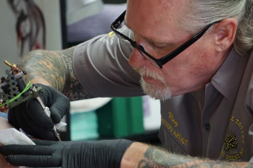 Tätowierer sticht seinem Kunden ein neues Tattoo