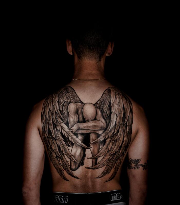 Symbolbild Chirurgische Tattooentfernung: Mann mit einem großflächigen Rückentattoo