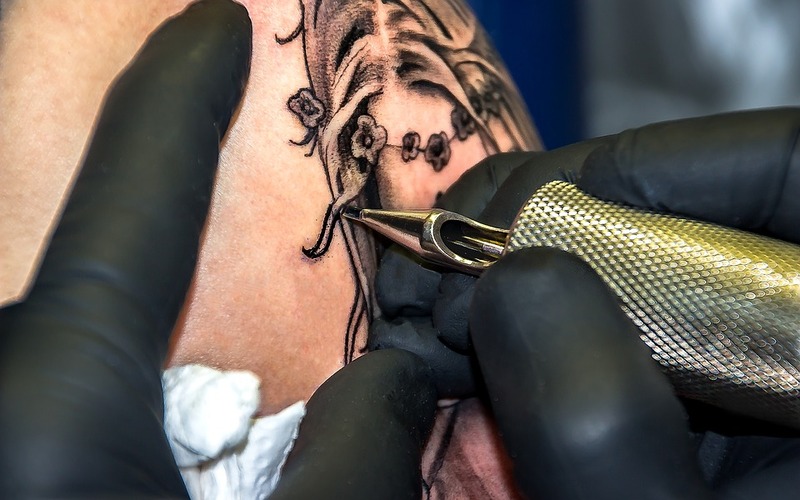 Symbolbild Tattoofarben Inhaltsstoffe: Schwarzes Tattoo wird gestochen