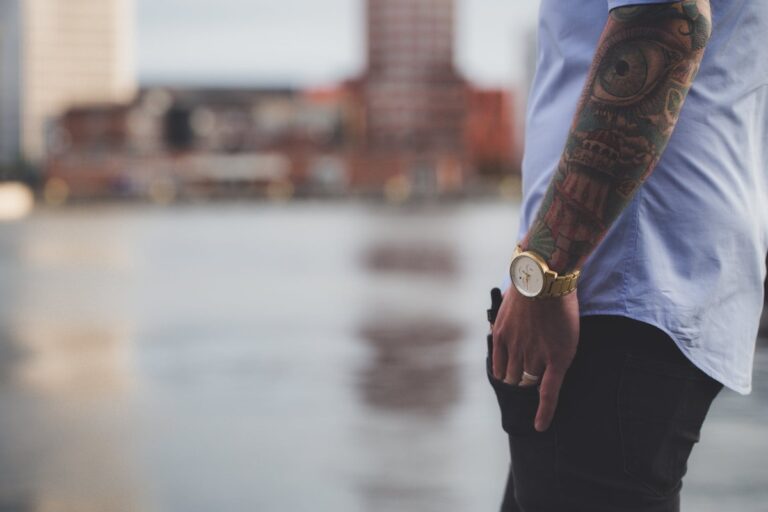Symbolbild Cover-up Tattoo entfernen: Mann mit bunten Tattoos am Unterarm