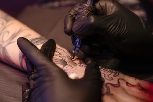 Symbolbild frisches tattoo entfernen: Frischen Tattoo wird gestochen