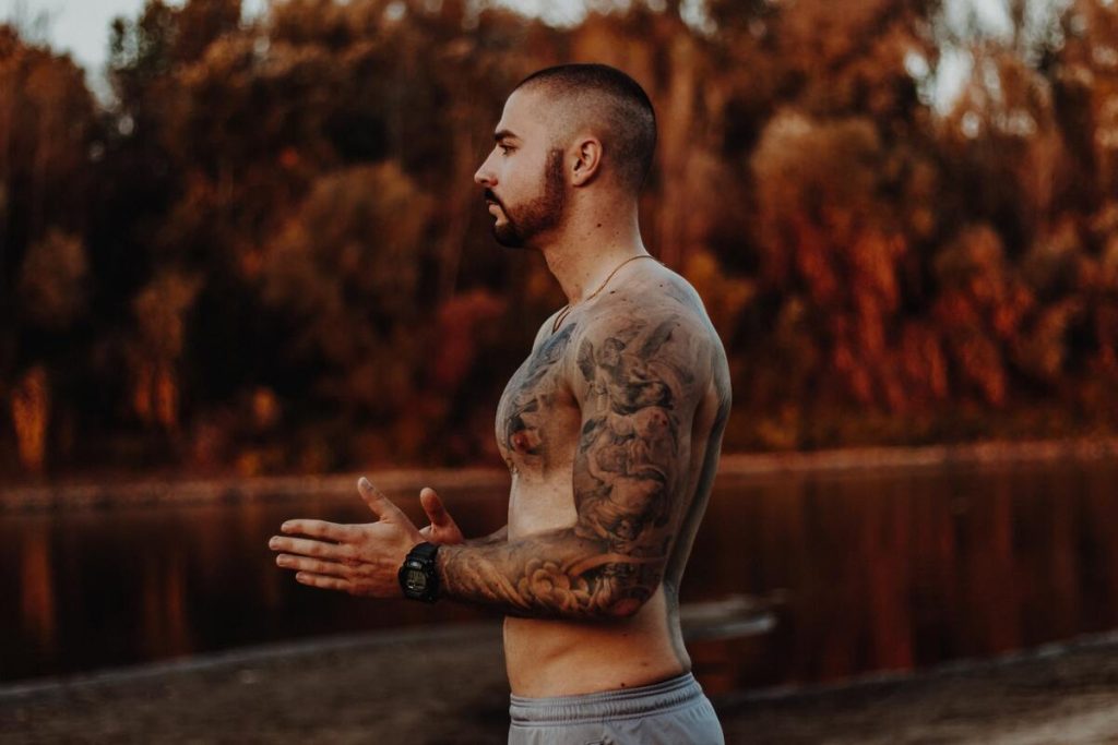 Symbolbild Cover-up Tattoo Oberarm: Mann mit Arm-Tattoos, das Schultern auch bedeckt