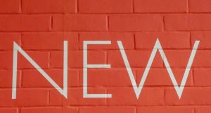 Symbolbild PicoSure® Pro Laser: Schriftzug „New“ auf roter Ziegelsteinmauer